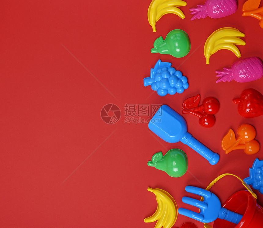 儿童塑料玩具以水果和桶为形式红色背景复制空间图片