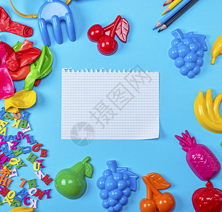 在儿童玩具中的蓝色背景笔记纸上撕破空白纸复制空间图片