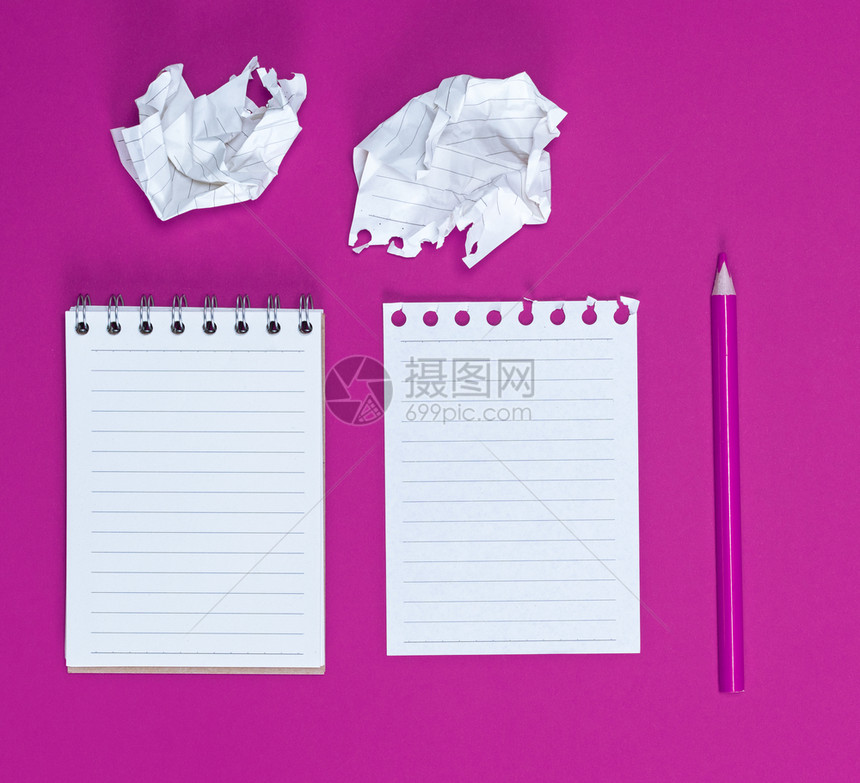 笔记本上面有空白纸两张折叠和粉红色背景的木铅笔图片