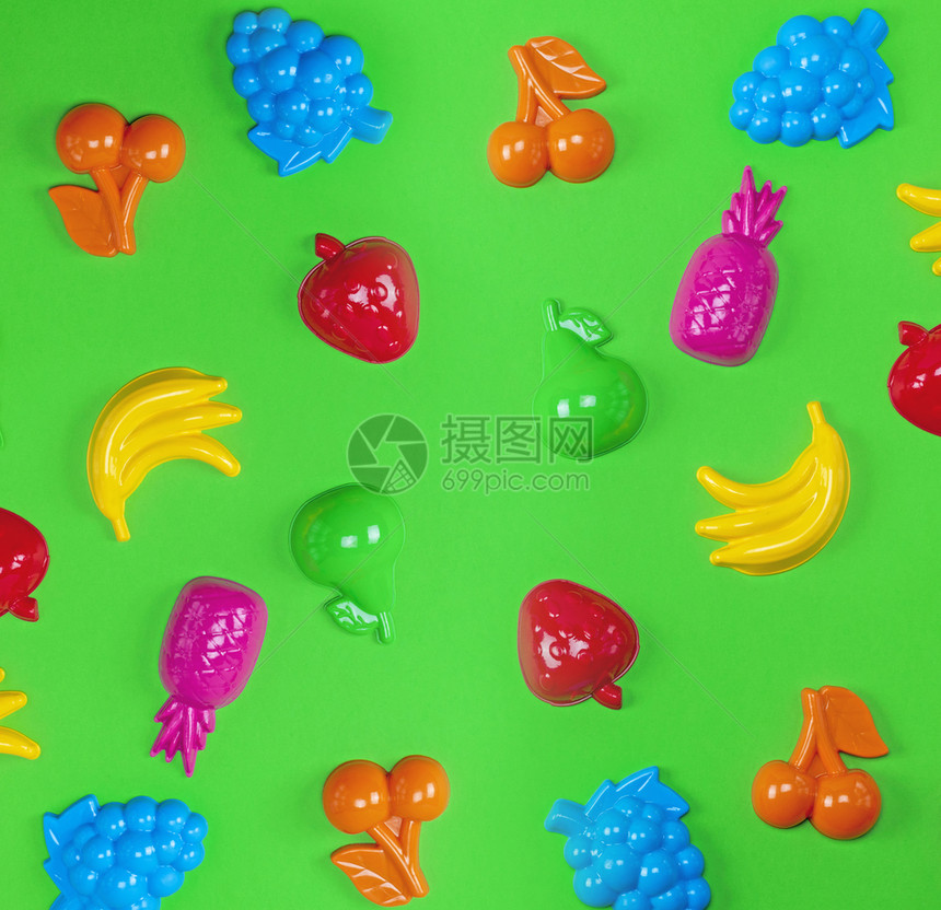 绿色背景的多彩塑料玩具水果关闭图片