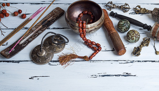 铜碗祈祷珠鼓和其他藏族宗教用具于白木背景的冥想和替代药物图片