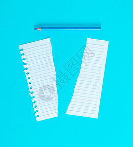 以半白的纸和蓝色背景的木形钢笔撕裂关闭图片
