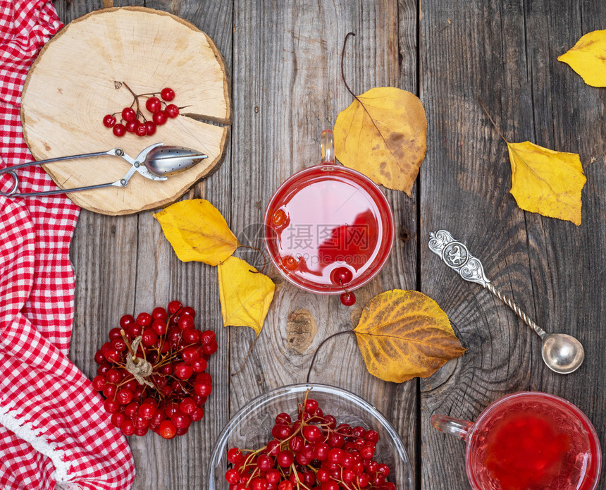 用透明玻璃杯盛着新鲜的viburnum浆果制成的茶灰色木桌上放着新鲜的红色浆果俯视图图片