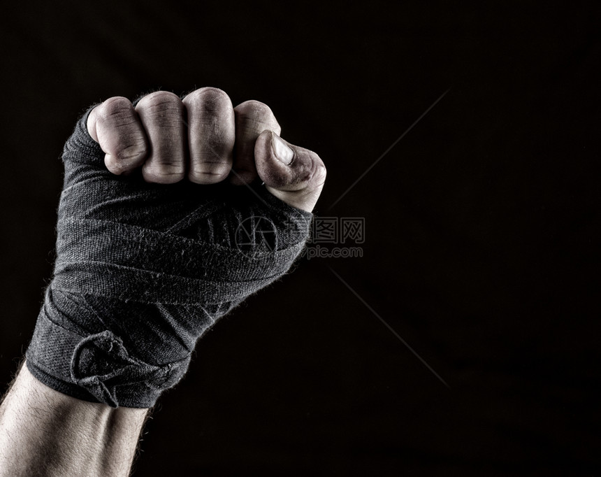 以黑色纺织绷带包着的运动员举起拳头团结的姿态图片