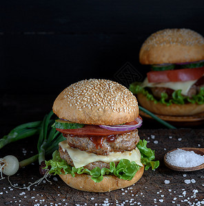 三明治加两块肉饼奶酪和蔬菜棕色木板上的芝士汉堡图片