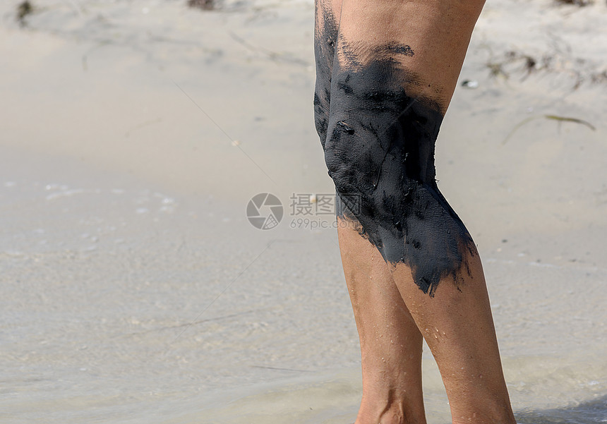 处理海岸上脚的泥巴接缝女身体的碎片图片