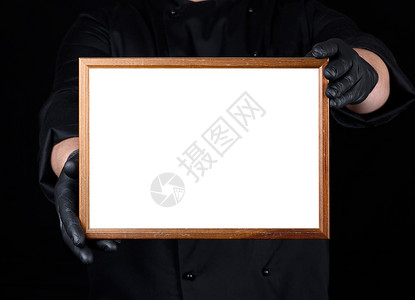 用黑色制服和乳胶戴大厨服和乳胶手套持带白色空间的木板框写模图片