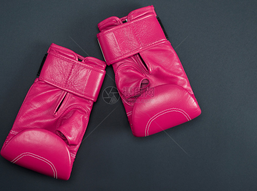 黑色背景顶视面的新型粉色运动拳击手套图片