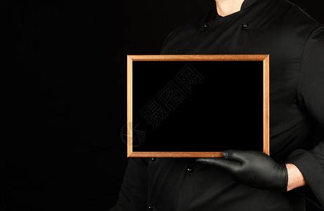 穿黑色制服和乳胶手套的厨师装黑色制服和乳胶手套装有空木板框复制间图片