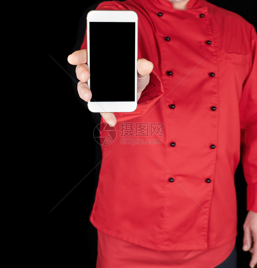 穿红制服的厨师拿着白黑屏幕的色智能手机图片