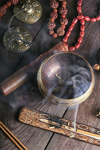 铜歌碗棕色桌上的木棍烧香背景图片