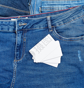 蓝牛仔裤背景的空白纸名片背景图片