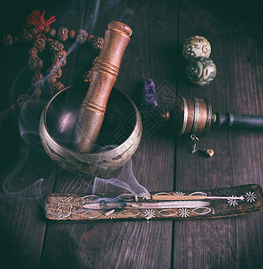 铜歌碗和棕色桌上的木棍背景图片
