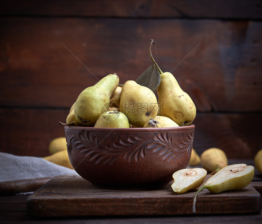 在桌子上的棕土碗里熟的青梨子关门图片