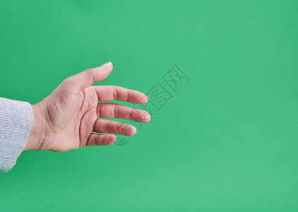 女手显示在绿色背景上持有物体的手势图片