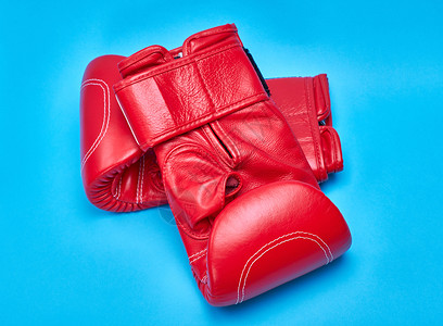 一对蓝色背景的红皮拳击手套背景图片