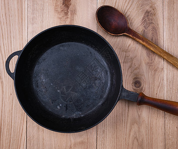 黑色圆煎锅木制手柄放在桌顶视图上图片