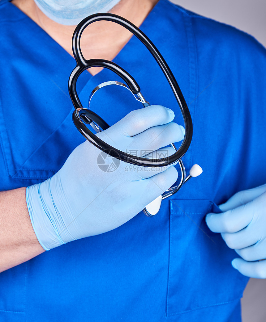 蓝色制服和乳胶手套的医生带有黑色听诊器选择地聚焦图片