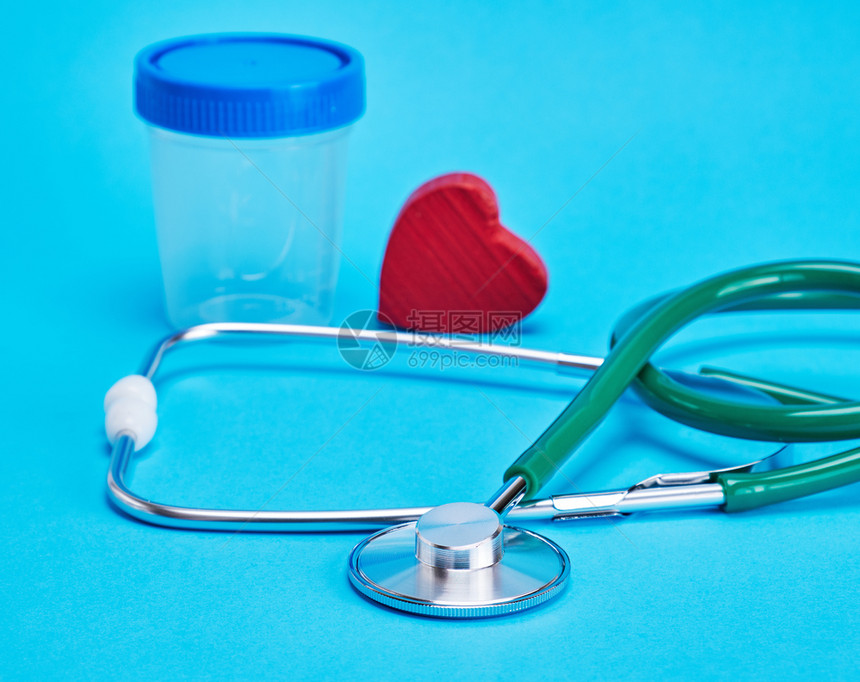 蓝色背景的绿医学听诊器和红装饰心脏图片