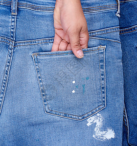 经典蓝牛仔裤女手卡在蓝牛仔裤的后口袋里闭紧整身背景