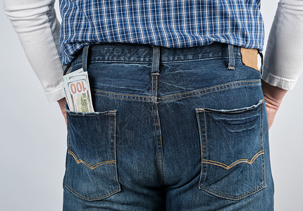 白底蓝牛仔裤的后袋里一堆纸钞背景图片