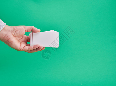 绿色背景名片绿色背景复制空间的女手持白纸商业名片背景