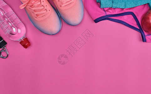 粉红色运动鞋和其他适合粉红色背景顶视图的健身品背景图片