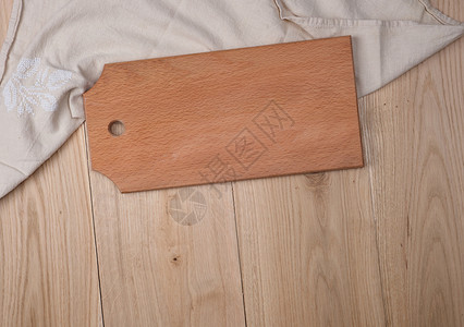 橡木板桌上的形长方切割板和厨房毛巾背景图片