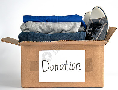 鞋装装在棕色纸盒中的折叠衣服在白色背景上赠入帮助有需要的人概念背景