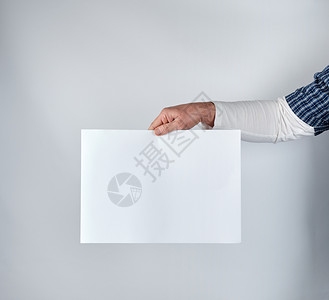 男子持有空白的长方形纸页空字母间图片