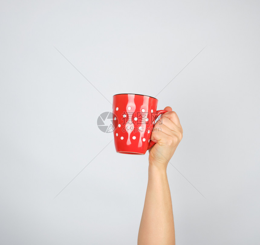 白色背景的女用手红陶瓷杯举起手来图片