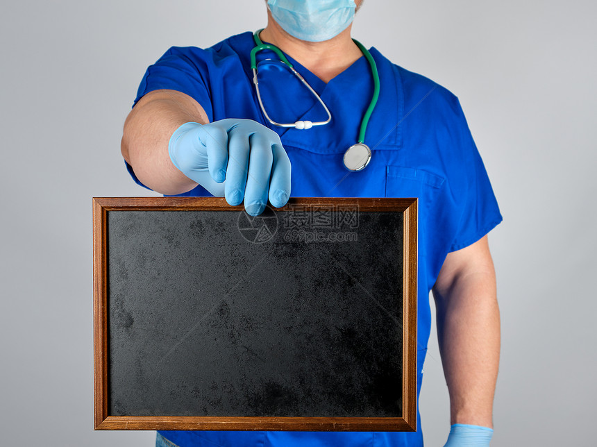 蓝制服医生和无菌乳胶手套持木框黑色空白字母背景灰色图片