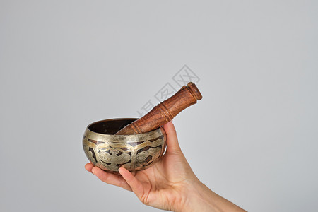 白色背景的女用手铜碗和木棍背景图片