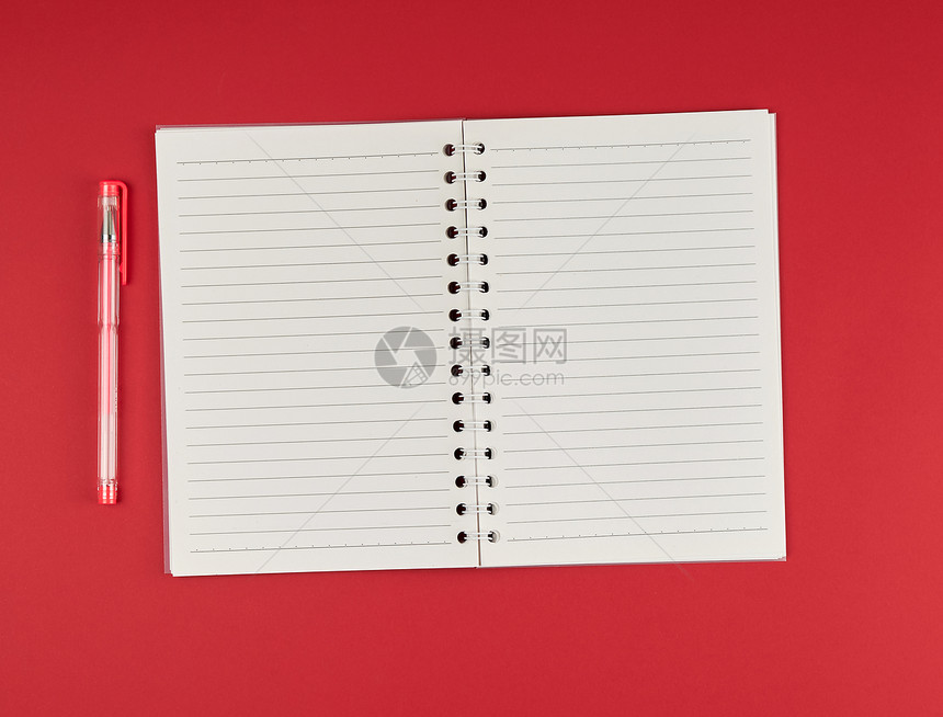 在红背景顶视图空白纸上打开线和凝胶笔的记本图片