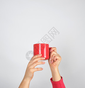 女手握红色陶瓷杯灰背景图片
