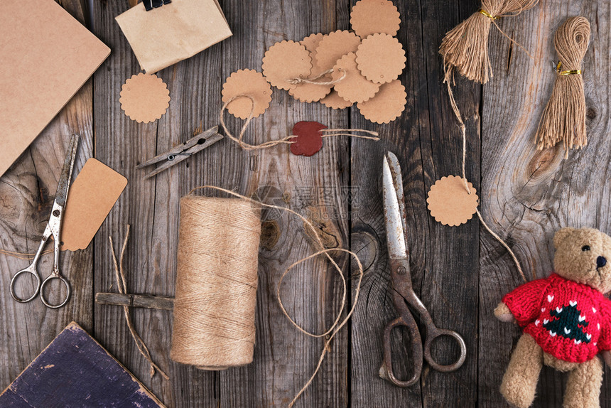 棕色绳索纸标签和旧剪刀的圆圈灰色木背景用于制作手工艺品的物图片