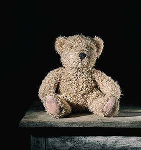 棕色柔软泰迪熊坐在旧木背景上古老的董图片