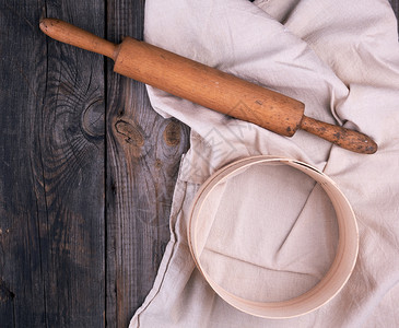 面粉灰木背景刺绣和圆筛子的纺织品巾上旧木板滚动老针图片