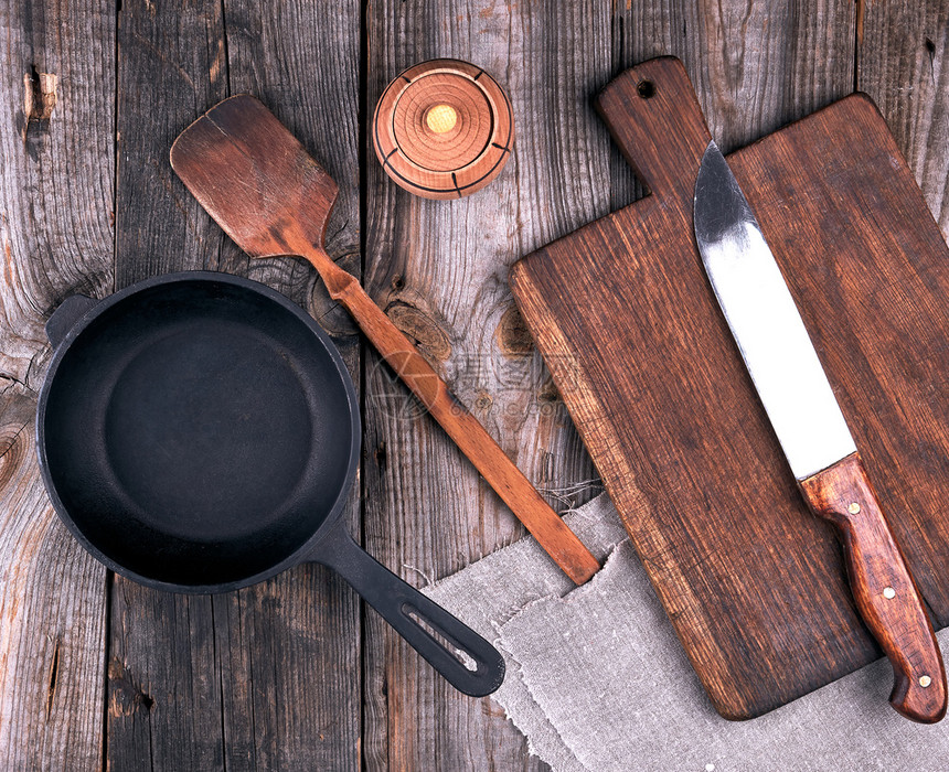 铁锅手柄木板和刀子放在灰色桌顶的视图上图片