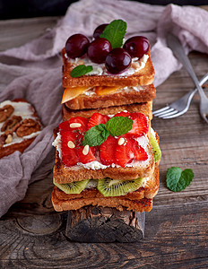 白面包中的法式吐司加干酪草莓木薯白板上的樱桃图片