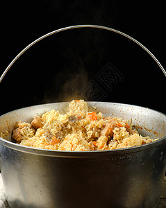 Pilaf是一种东方煮饭菜含有脂肪和肉片及香料用大铝制的黑底锅炉煮饭图片