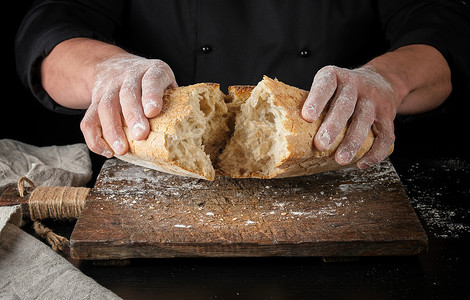 身穿黑色制服的面包师穿黑色制服半个面包碎成白粉包图片
