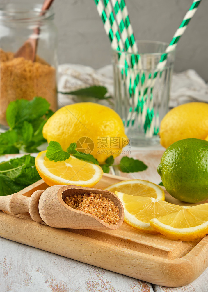 成熟的黄柠檬和褐糖白木板上一串新鲜薄荷柠檬汁的原料图片