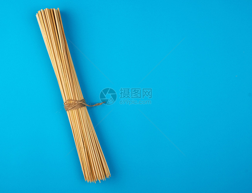 蓝背景空间的烧烤用木竹棍捆绑的图片