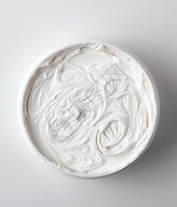 在塑料罐子里的厚白色化妆奶油顶层风景图片