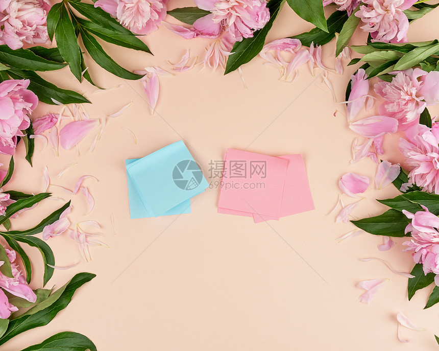 桃子背景上的空粉色和蓝纸贴周围一束盛开的花朵最顶端视野图片