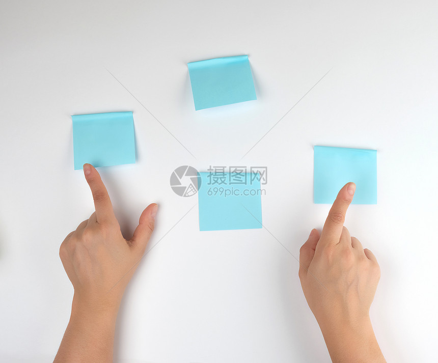 白色背景上有很多蓝色贴纸和两只女手指着它们概念背景图片