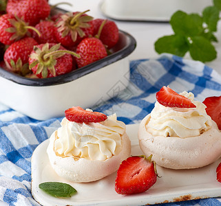 奶油和新鲜草莓的烤蛋甜饼红莓酱的盘子后面图片