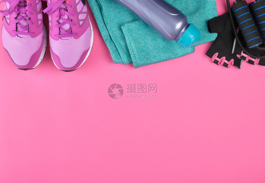 粉红妇女运动鞋一瓶水手套和跳绳用于粉红背景顶视复制空间平铺运动图片