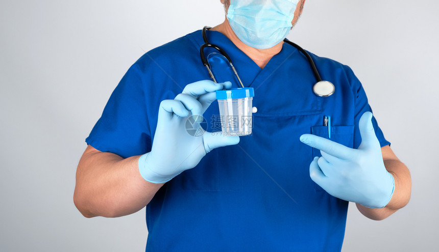 穿蓝色制服和乳胶手套的医生携带一个空塑料容器用于抽取灰底尿液样本图片